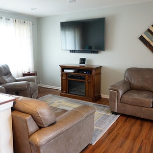 Kleines, Offenes Mediterranes Wohnzimmer mit blauer Wandfarbe, Laminat und braunem Boden in Milwaukee