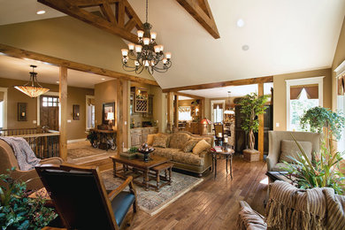 Inspiration for a large rustic open concept medium tone wood floor living room remodel in Other with beige walls, a standard fireplace, a stone fireplace and a wall-mounted tv