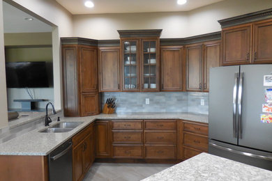 Open concept kitchen - mid-sized traditional l-shaped ceramic tile and gray floor open concept kitchen idea in Chicago with a double-bowl sink, recessed-panel cabinets, medium tone wood cabinets, quartzite countertops, blue backsplash, ceramic backsplash, stainless steel appliances and an island