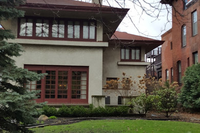 Large beige two-story stucco house exterior idea in Other with a hip roof and a metal roof