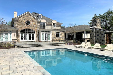 Large transitional multicolored two-story stone house exterior idea in Baltimore with a hip roof and a shingle roof