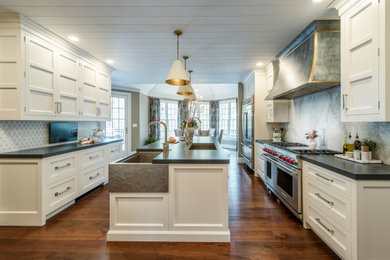 This is an example of a large transitional eat-in kitchen in Philadelphia with an undermount sink, recessed-panel cabinets, white cabinets, quartz benchtops, grey splashback, marble splashback, stainless steel appliances, light hardwood floors, with island, grey benchtop and timber.