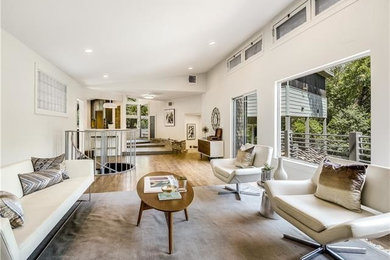 Living room - mid-sized mid-century modern open concept medium tone wood floor living room idea in Austin with white walls