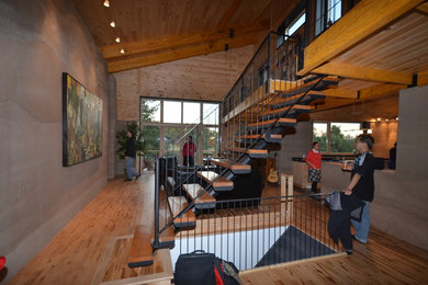 Inspiration for a large contemporary loft-style light wood floor living room library remodel in Toronto with beige walls and no tv