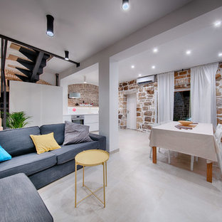 This is an example of a mediterranean living room in Other with porcelain flooring, a freestanding tv and beige floors.
