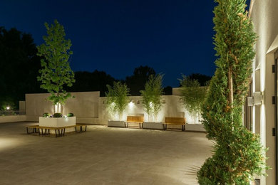 Expansive contemporary backyard patio in New York with a container garden, natural stone pavers and no cover.