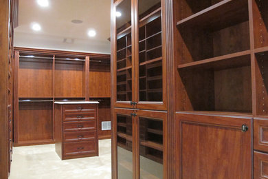 Inspiration for a huge timeless gender-neutral carpeted walk-in closet remodel in New York with recessed-panel cabinets and dark wood cabinets