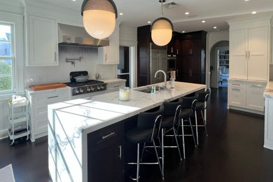 Example of a large trendy u-shaped dark wood floor and brown floor eat-in kitchen design in New York with a single-bowl sink, recessed-panel cabinets, white cabinets, quartz countertops, white backsplash, glass tile backsplash, stainless steel appliances, an island and white countertops