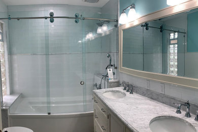 Large elegant master white tile and glass tile ceramic tile, gray floor, double-sink and vaulted ceiling bathroom photo with furniture-like cabinets, white cabinets, a two-piece toilet, blue walls, an undermount sink, marble countertops, white countertops and a freestanding vanity