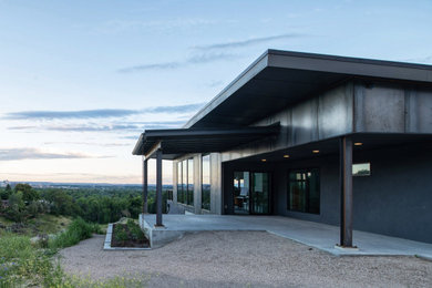 Example of a small gray two-story metal house exterior design in Boise with a butterfly roof and a metal roof