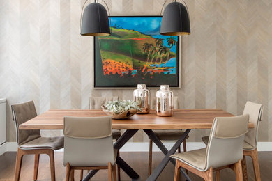 Example of a mid-sized island style dark wood floor and brown floor great room design in New York with beige walls and no fireplace