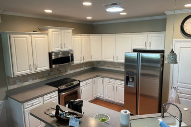 Example of a mid-sized classic l-shaped kitchen design in Charleston with white cabinets