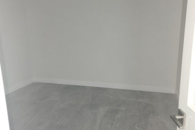 Ejemplo de armario vestidor unisex minimalista grande con armarios estilo shaker, puertas de armario grises, suelo de baldosas de cerámica y suelo gris