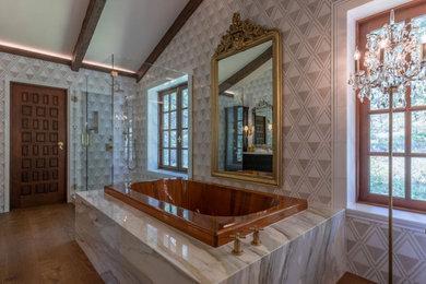 Inspiration for a huge eclectic master beige tile and marble tile medium tone wood floor, brown floor and exposed beam bathroom remodel in Miami with marble countertops, a hinged shower door and white countertops