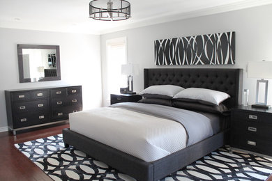 Photo of a large transitional master bedroom in Montreal with grey walls, medium hardwood floors and brown floor.