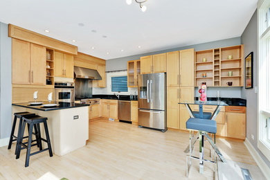 Inspiration for a large contemporary u-shaped light wood floor and beige floor eat-in kitchen remodel in Chicago with stainless steel appliances, an undermount sink, shaker cabinets, light wood cabinets, granite countertops and a peninsula
