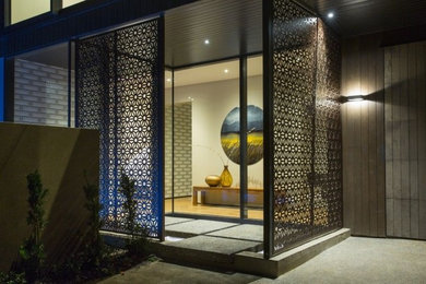 Modern entryway in Auckland with light hardwood floors.