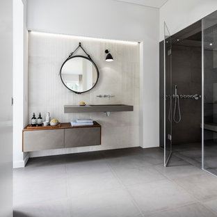 Idee per una grande stanza da bagno padronale moderna con ante lisce, ante grigie, doccia a filo pavimento, WC a due pezzi, piastrelle beige, piastrelle di pietra calcarea, pareti bianche, pavimento in pietra calcarea, lavabo integrato, top in pietra calcarea, pavimento grigio e top grigio