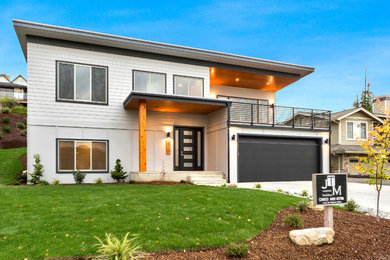 Minimalist white two-story concrete fiberboard exterior home photo in Seattle with a mixed material roof