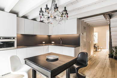 Esempio di una cucina minimal con lavello sottopiano, ante lisce, ante bianche, top in superficie solida, paraspruzzi grigio, paraspruzzi in gres porcellanato, elettrodomestici in acciaio inossidabile, pavimento in legno verniciato, nessuna isola, pavimento marrone, top grigio e travi a vista