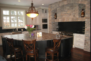 Example of a large classic l-shaped dark wood floor eat-in kitchen design in Chicago with a farmhouse sink, raised-panel cabinets, white cabinets, stainless steel appliances, an island, granite countertops and black backsplash