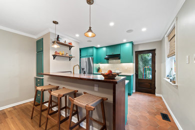 Inspiration for a mid-sized transitional terra-cotta tile eat-in kitchen remodel in Philadelphia with an undermount sink, shaker cabinets, green cabinets, wood countertops, stone tile backsplash, stainless steel appliances and brown countertops