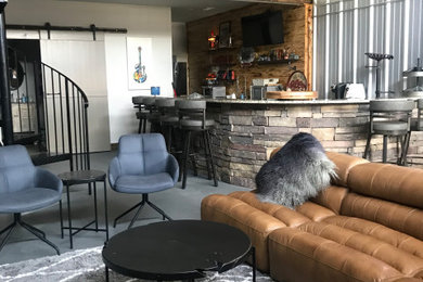Seated home bar - large industrial u-shaped concrete floor and gray floor seated home bar idea with flat-panel cabinets, gray cabinets and granite countertops