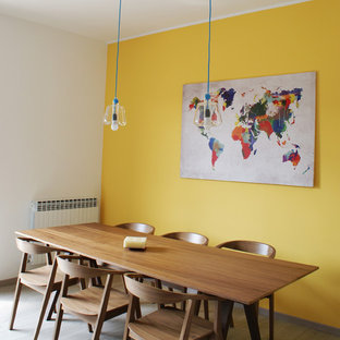 Nordisches Esszimmer mit gelber Wandfarbe und hellem Holzboden in Mailand