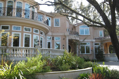 Large tuscan beige two-story stucco house exterior photo in San Francisco with a hip roof and a tile roof