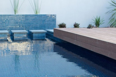 Imagen de piscina contemporánea de tamaño medio rectangular en patio trasero con entablado