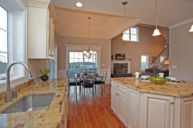 Elegant l-shaped medium tone wood floor eat-in kitchen photo in New York with an undermount sink, raised-panel cabinets, beige cabinets, granite countertops and stainless steel appliances