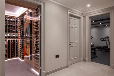 This is an example of a medium sized modern wine cellar in Surrey with marble flooring, storage racks and grey floors.