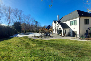 Photo of a huge traditional backyard stone landscaping in Charlotte with a fireplace.