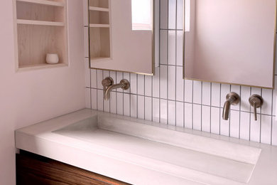 Bathroom - modern double-sink bathroom idea in Orange County with a trough sink and concrete countertops