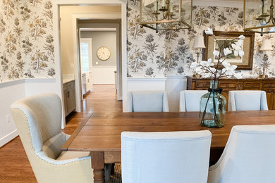 Large transitional separate dining room in DC Metro with white walls, medium hardwood floors, no fireplace, brown floor, coffered and wallpaper.