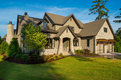 Large arts and crafts beige two-story mixed siding exterior home photo in Other with a clipped gable roof