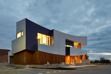 Photo of a large contemporary two-storey exterior in Perth with wood siding.