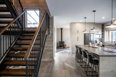Large minimalist wooden u-shaped open and wood railing staircase photo in Other