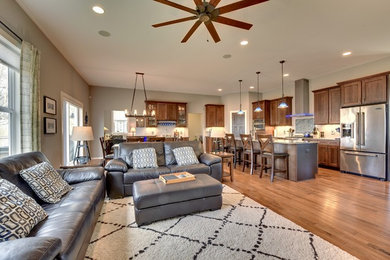 Living room - craftsman medium tone wood floor living room idea in Minneapolis with gray walls, a stone fireplace and a wall-mounted tv