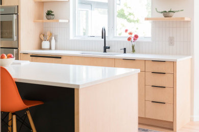 Example of a large danish l-shaped light wood floor eat-in kitchen design in Boston with an undermount sink, light wood cabinets, quartz countertops, white backsplash, ceramic backsplash, stainless steel appliances, an island, white countertops and flat-panel cabinets