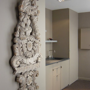 Создайте стильный интерьер: маленькая линейная кухня-гостиная в современном стиле с врезной раковиной, фасадами с декоративным кантом, бежевыми фасадами, бежевым фартуком, ковровым покрытием и коричневым полом без острова - последний тренд