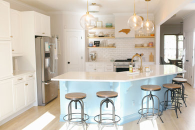 Diseño de cocinas en U minimalista grande con armarios con paneles con relieve, puertas de armario blancas y una isla