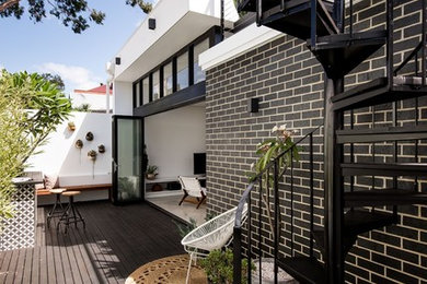 This is an example of a small contemporary one-storey brick grey exterior in Perth with a flat roof.