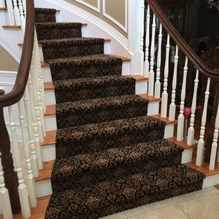 Imagen de escalera curva, clásica, de tamaño medio, con escalones de madera y contrahuellas enmoquetadas