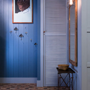 Cette photo montre une petite entrée éclectique avec un mur bleu.