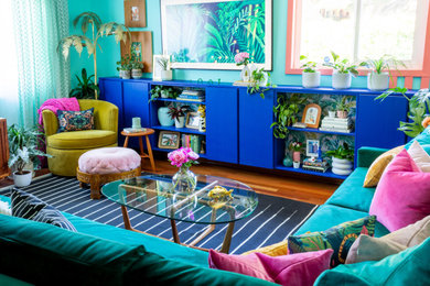 Diseño de salón cerrado exótico de tamaño medio con paredes azules, suelo de madera en tonos medios, televisor colgado en la pared, panelado y suelo rojo