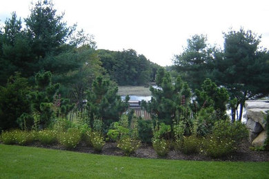 Large backyard full sun garden in Portland Maine with a garden path.