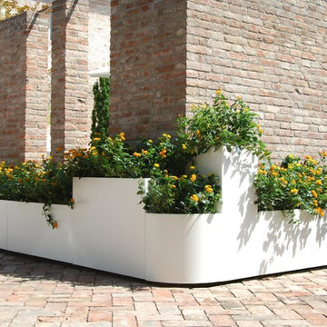 White planters to adorn country house with brick wall - Fioriere bianche