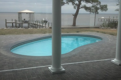 This is an example of a beach style pool in Other.
