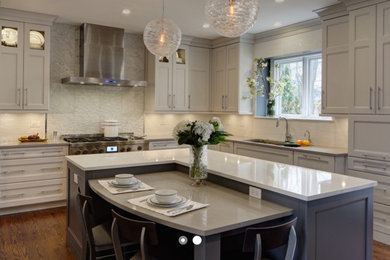 Inspiration for a mid-sized transitional l-shaped medium tone wood floor and brown floor eat-in kitchen remodel in Chicago with an undermount sink, shaker cabinets, white cabinets, quartz countertops, white backsplash, marble backsplash, stainless steel appliances, an island and white countertops